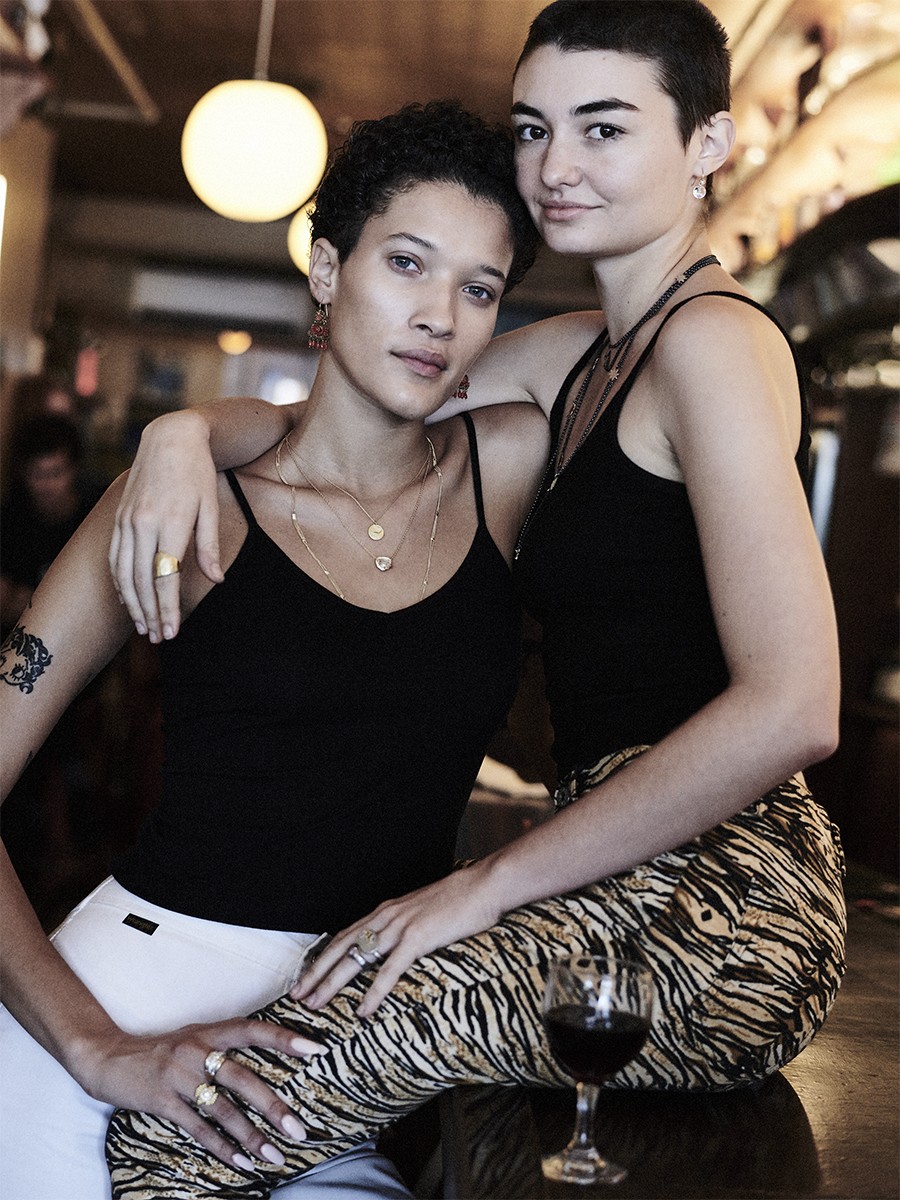 two women from lucien nyc pose in the bar in black tank tops with short cropped haircuts