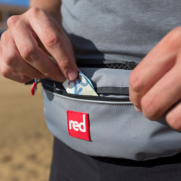 Dry pouch attached to grab handle on paddle board.