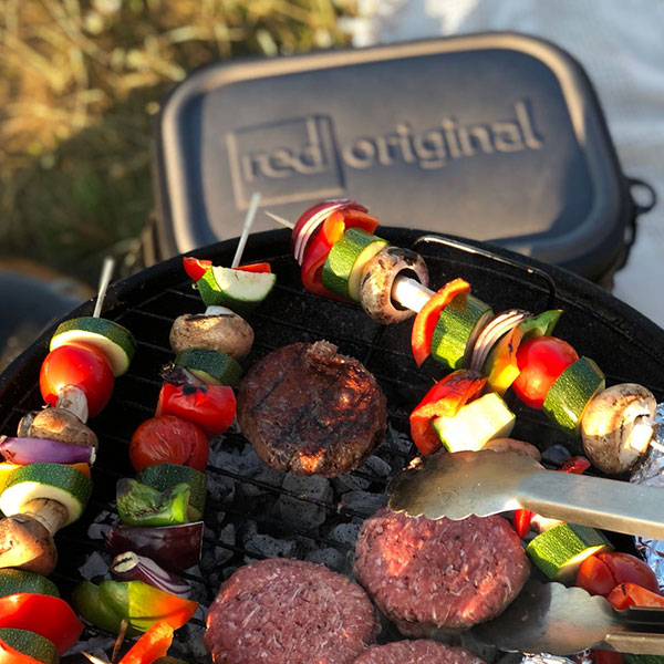 Cooking on BBQ with Cool bag in background.