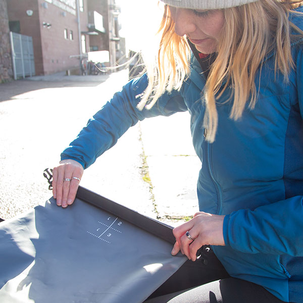 Female rolling up a dry bag