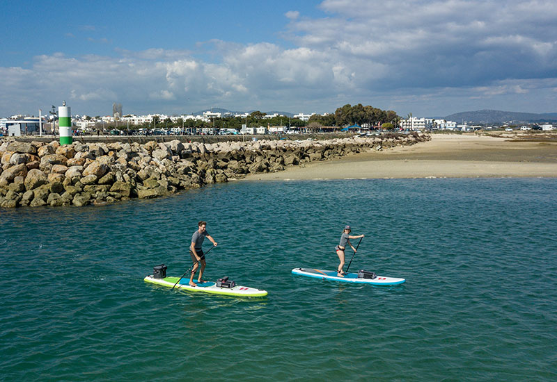 A Man And A Woman Paddle Boarding In The Sea