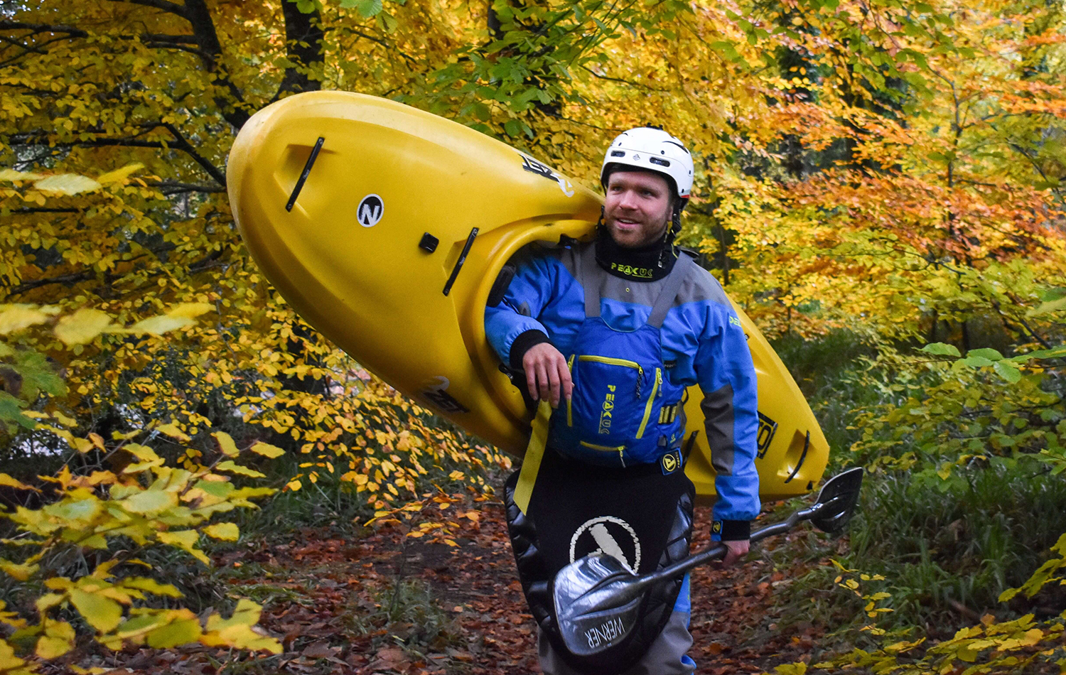 A Man Carrying A Kayak Over His Shoulder