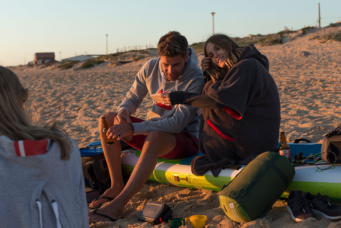Male and Female sitting on beach in Towelling Robe