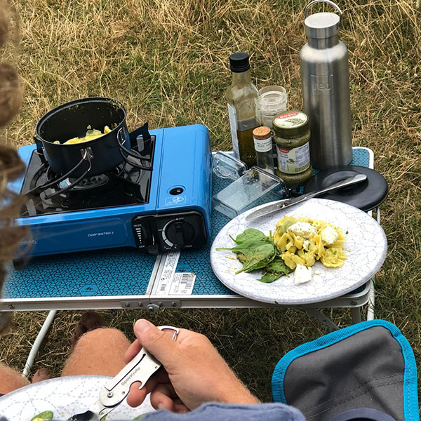 Over the should image of stove and drinks bottle on table.