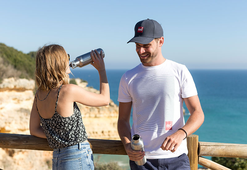 Relaxing on a clifftop wearing the Red Original Swell Lines t-shirt