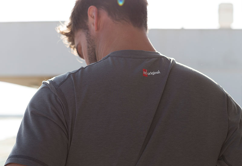 Man putting on a Red Original Mens Performance T Shirt