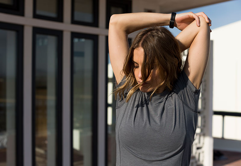 woman stretching whilst wearing the Red Original Women's Performance T Shirt