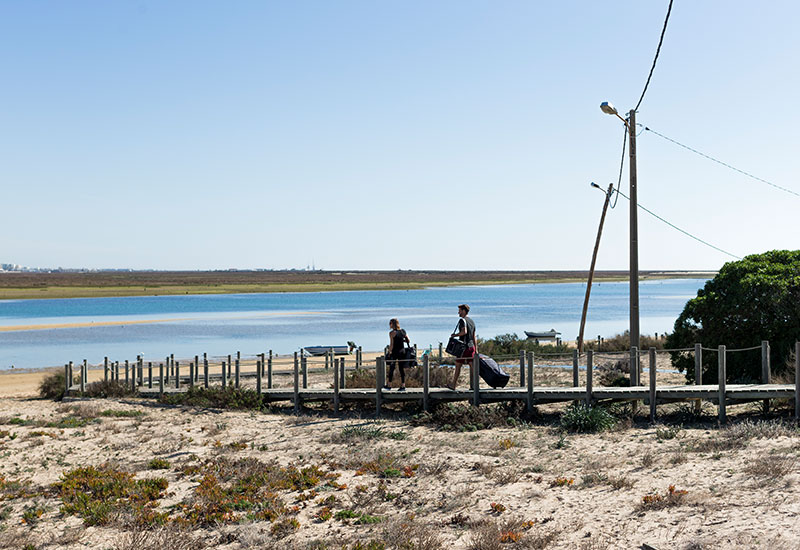 couple carrying equipment to the beach