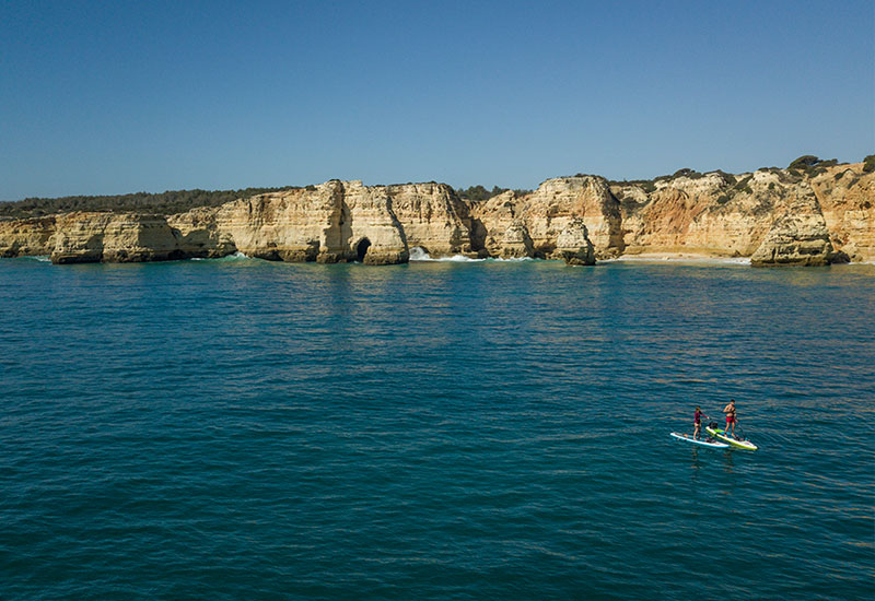 Coupe paddle boarding on the Portugal coastline