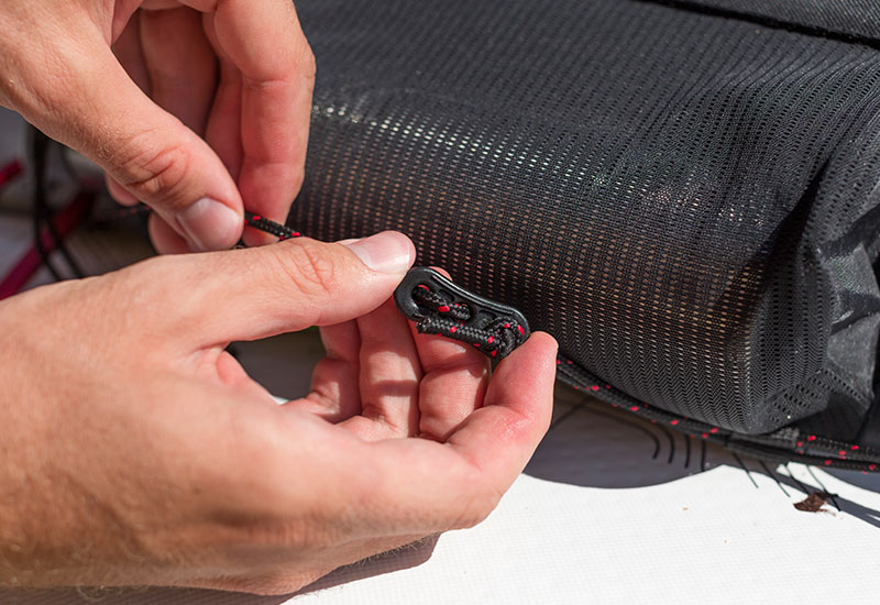 tightening the luggage tensioning system on the deck bag to a sup