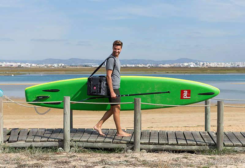 Man carrying a sup whilst wearing the Red Original Mens Performance T Shirt