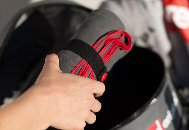 Red Original Microfibre Towel being packed into a deck bag