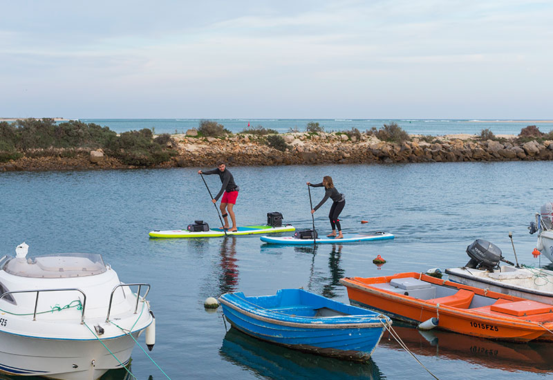 Couple paddle boarding in Portugal