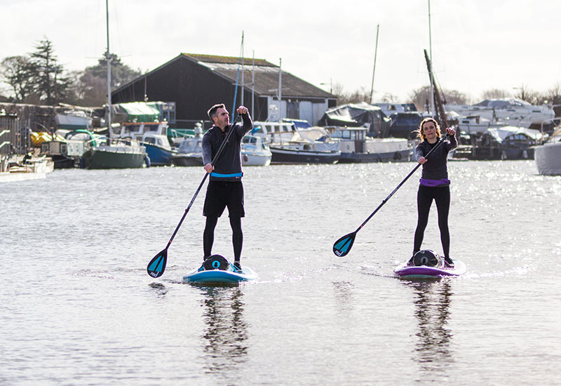 paddle boarding with Red Original Roll Top Dry Bags on board