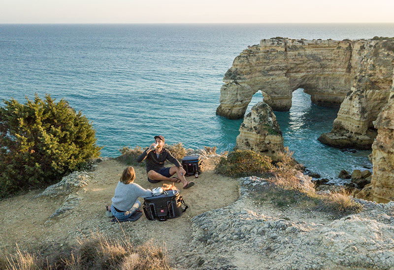 Couple having a camp fire on a cliff top