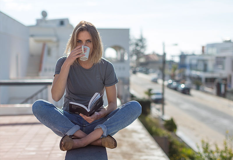 female drinking coffee whilst wearing the Red Original Women's Performance T Shirt