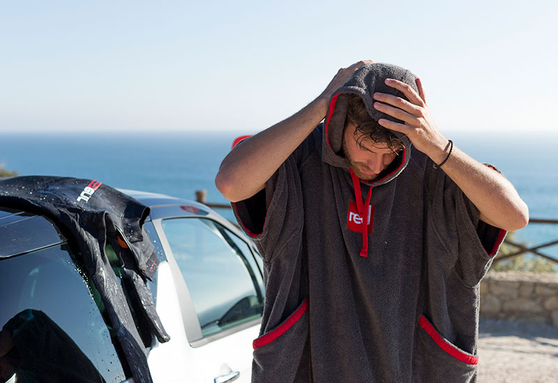 man drying his hair with Red Original luxury changing robe