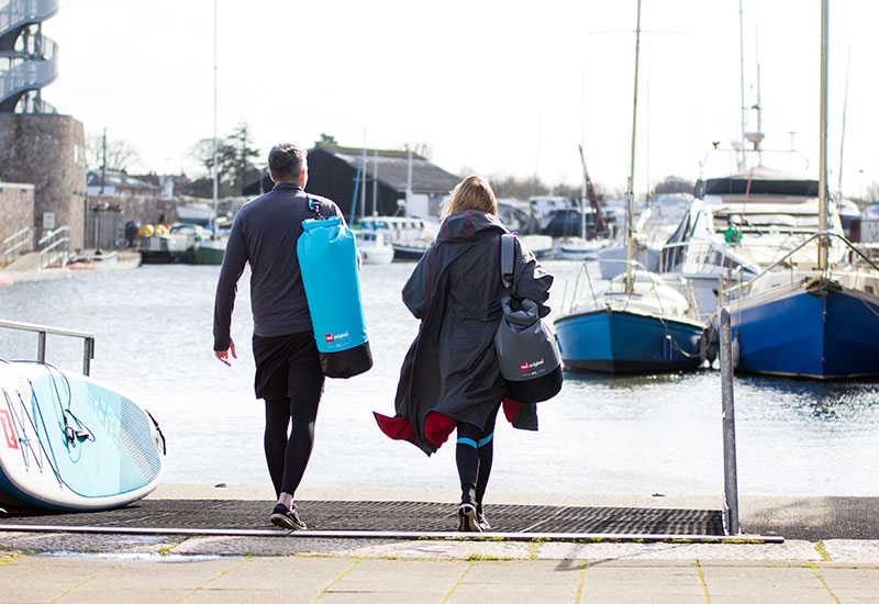 Couple carrying Red Original Roll Top Dry Bags