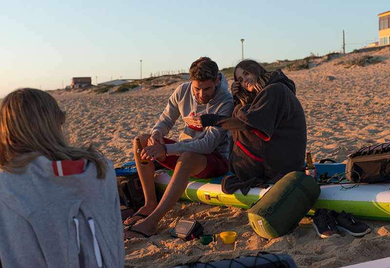Woman watching the sunset on the beach wearing her Red Original Luxury Change Robe